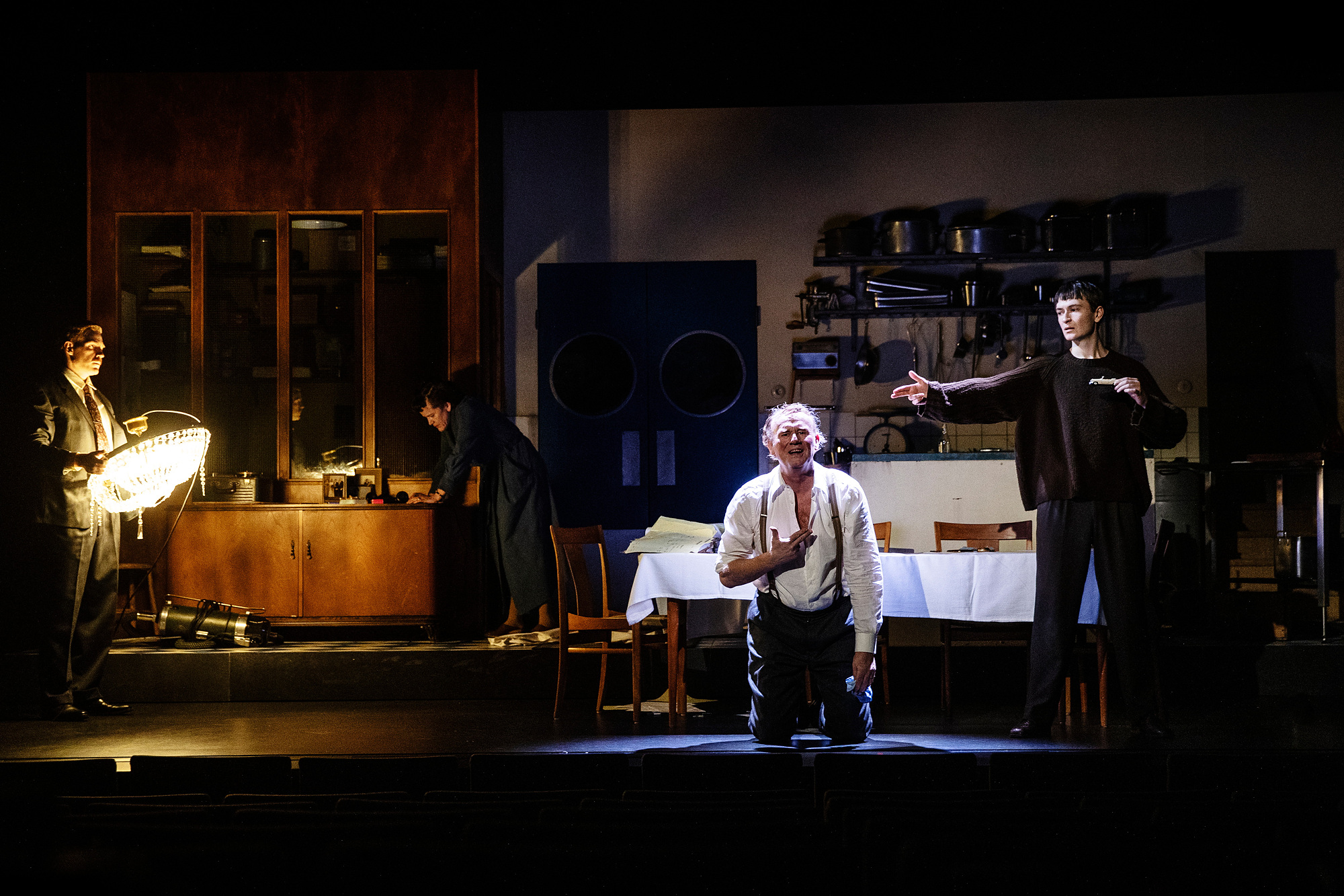 Fyra personer på en scen. En man knäböjer till höger.