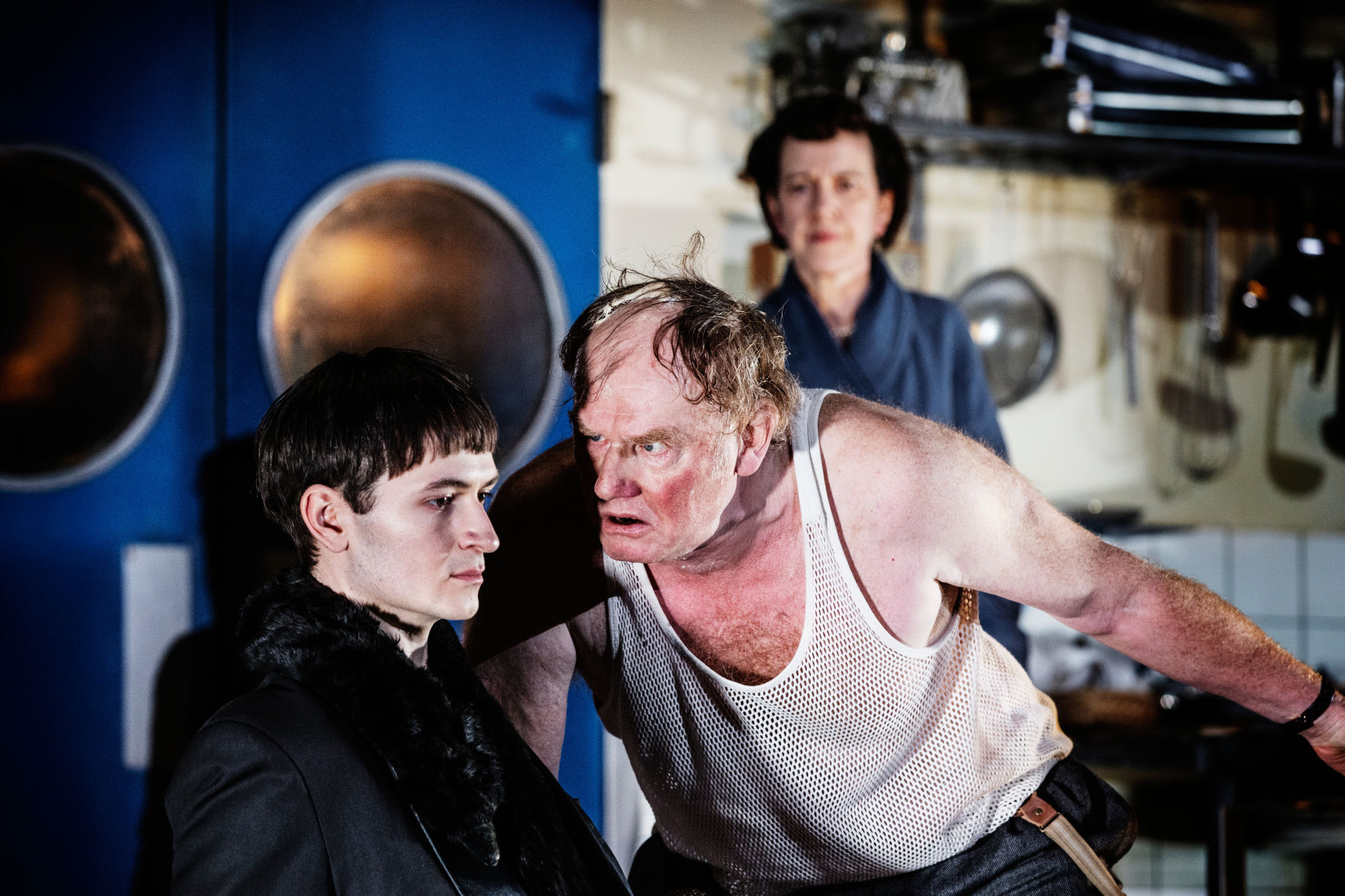 Tre personer. En närmar sig den ene hotfullt.