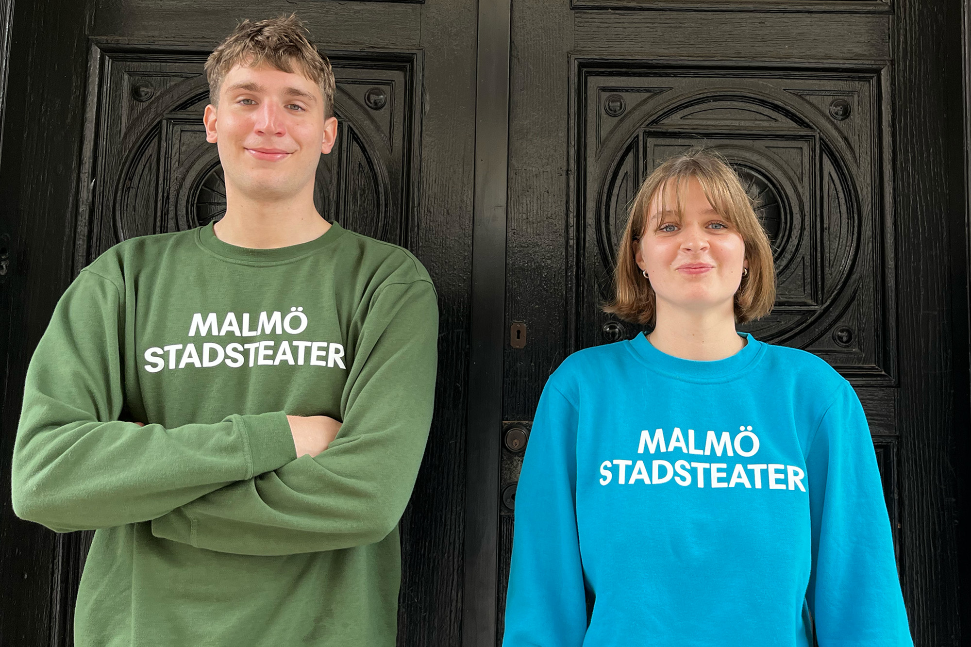Två personer med sweatshirt i blå och grön och Malmö Stadsteater-logga 