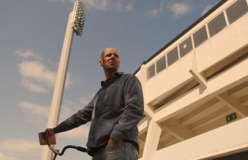 Person står med cykel utanför fotbollsstadion