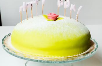 en prinsesstårta med utbrunna ljus som bildar Happy Bday