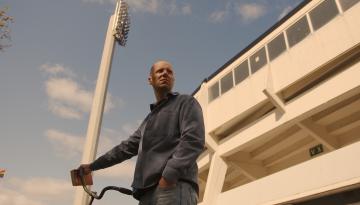 Foto Johan Sundell Person står med cykel utanför fotbollsstadion
