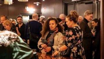 Två personer beställer vin i foajébaren