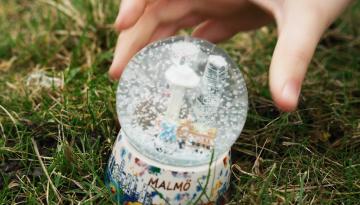 Foto Nicholas Wakeham En barnhand tar tag om en snöglob som står på en gräsmatta
