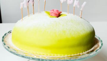 en prinsesstårta med utbrunna ljus som bildar Happy Bday