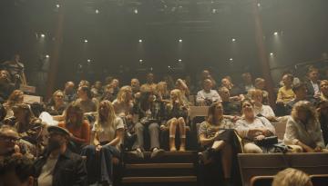 Många personer i en teatersalong