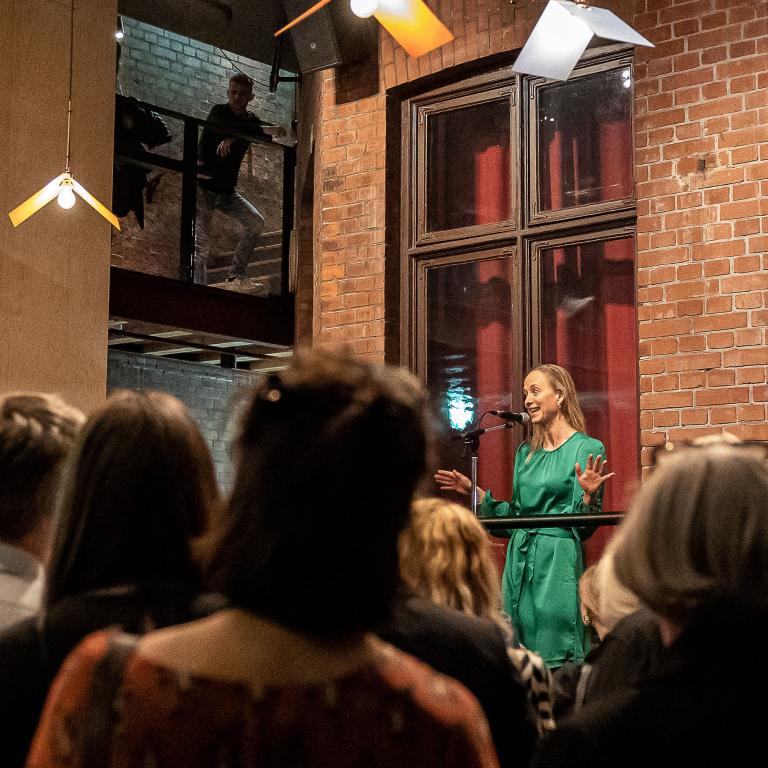 Foto:Jenny Baumgartner Regissören Sara Cronberg talar till publiken på Malmö Stadsteaters innergård på Kalendegatan.