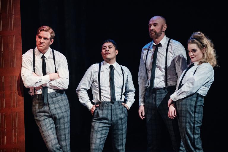 Fyra skådespelare i rutiga byxor, skjorta, slips och hängslen