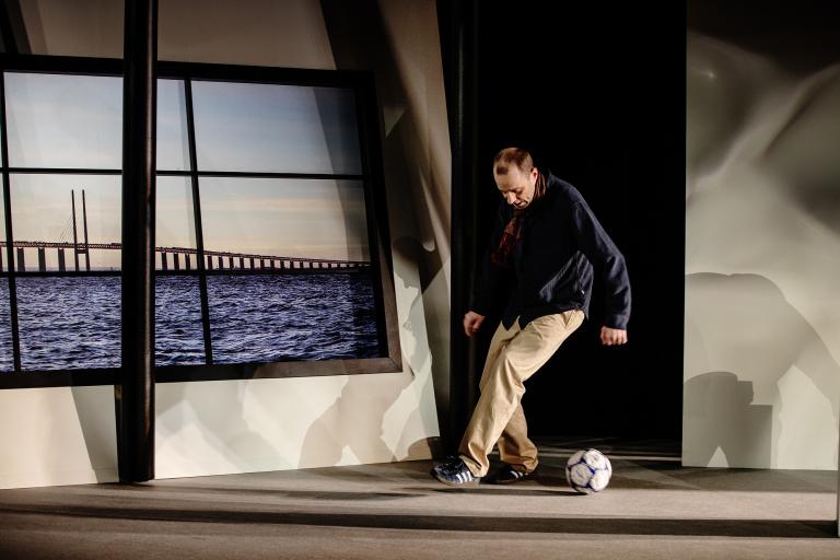 Man spelar fotboll i dunkelt ljus