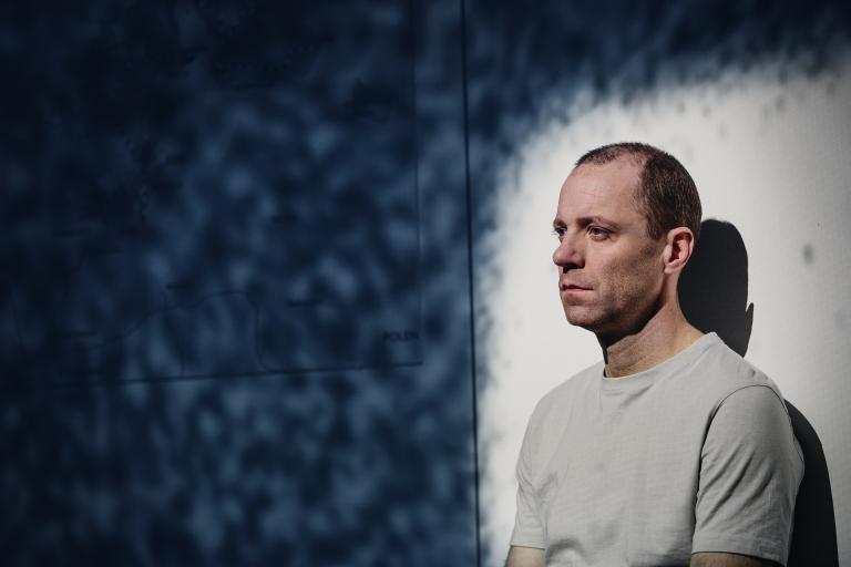 Man sitter i strålkastarljus med flimrande mönster runt omkring
