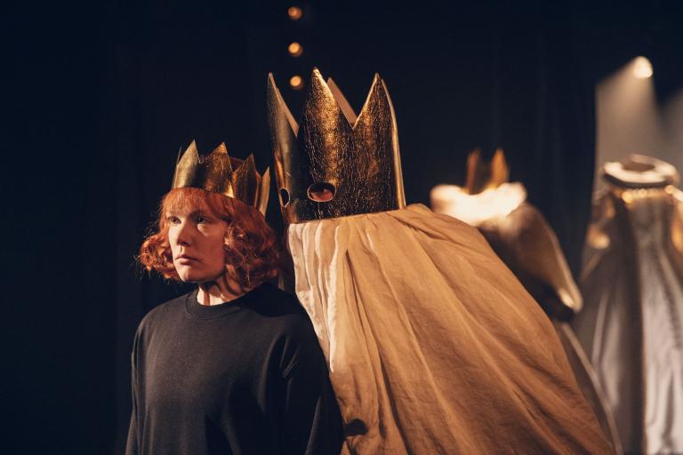Hamlet i kungakrona bakom honom ett spöke i guldkrona med plats för ögon