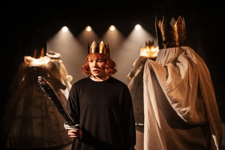 Hamlet med svärd. Bakom honom står ett spöke med guldig krona 
