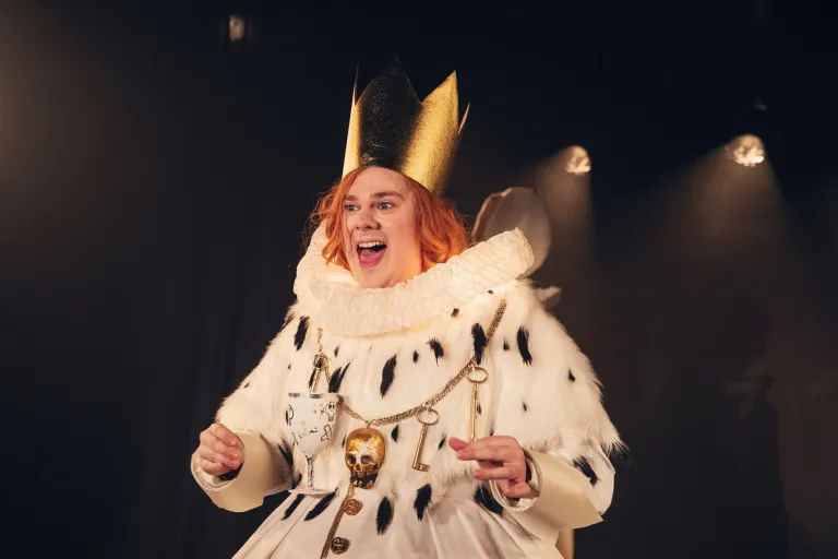 Skådespelare, skumma pappan med kungakrona, shakespearekrage och döskalle runt halsen