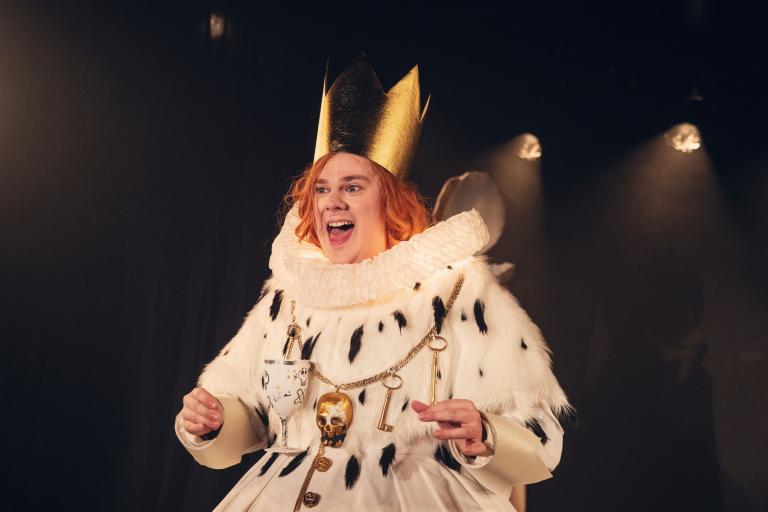 Skådespelare, skumma pappan med kungakrona, shakespearekrage och döskalle runt halsen