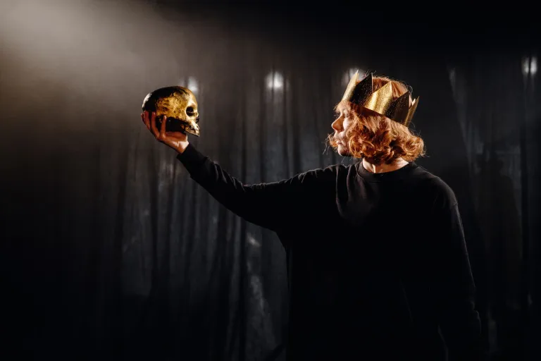 skådespelare med kungakrona håller i döskalle - hamlet att vara eller ikke vara
