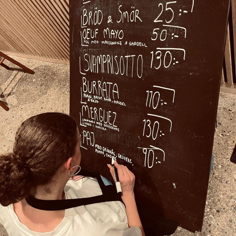 Menyexempel Teatercaféet innan föreställning En person som skriver en meny på en griffeltavla