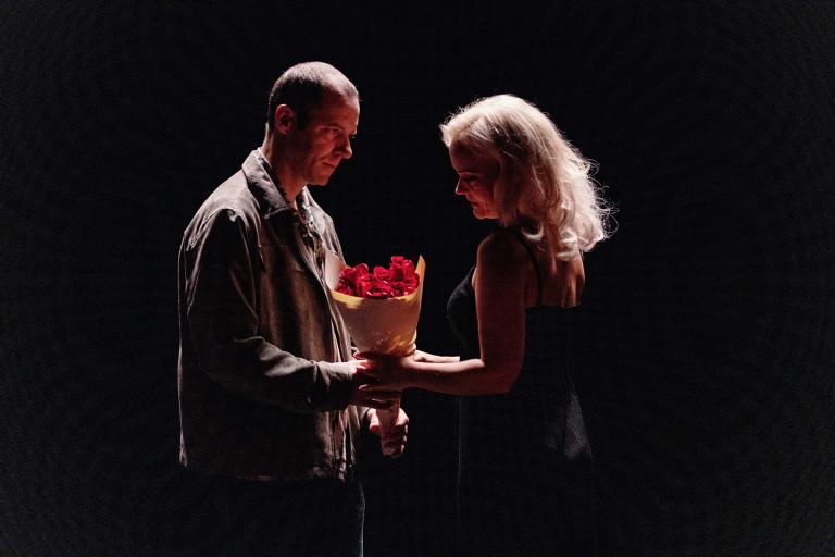 En person ger blommor till en annan person.