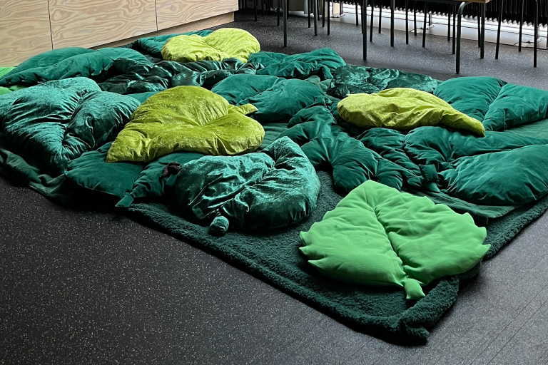 Malmö Stadsteater Grön matta med kuddar i form av löv i olika gröna nyanser