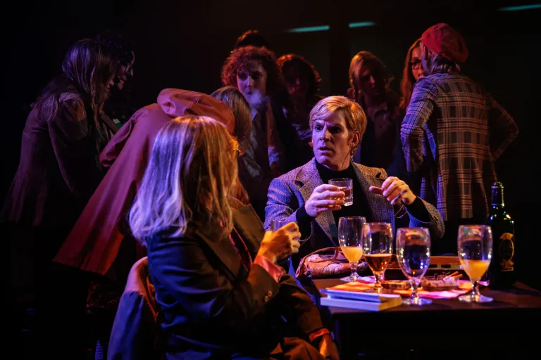 Skådespelare i bar- eller klubbsituation, samtal över glas med alkoholhaltigdryck.