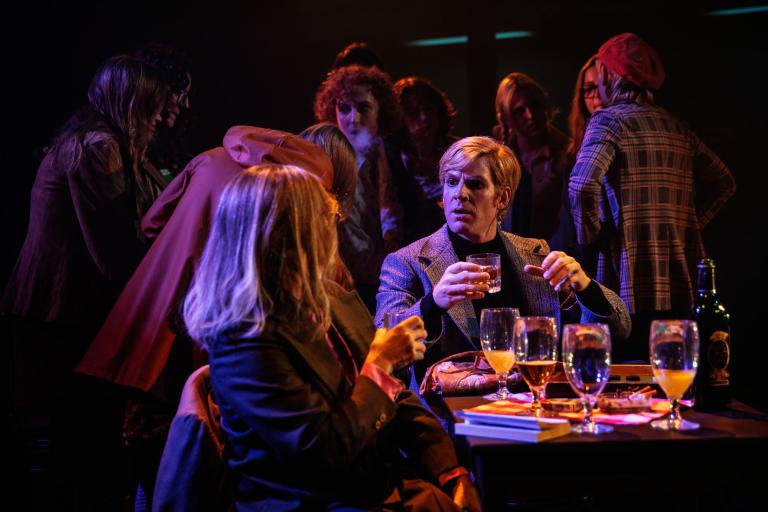 Skådespelare i bar- eller klubbsituation, samtal över glas med alkoholhaltigdryck.