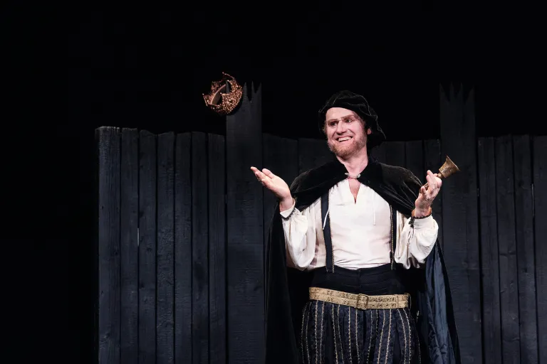 Skådespelaren är William Shakespeare, med cape och klocka 