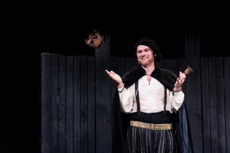 Skådespelaren är William Shakespeare, med cape och klocka 
