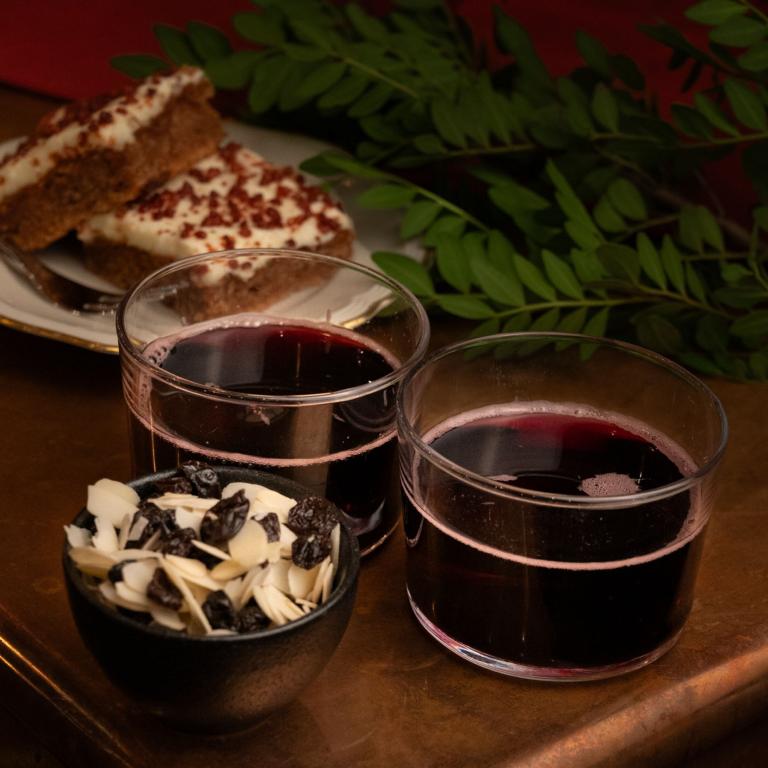 Två glas glögg, kakor och en skål med russin och mandel