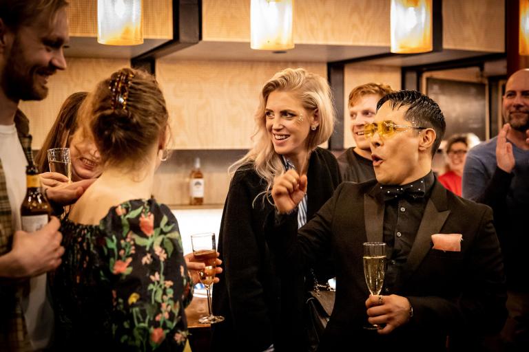Foto: Jenny Baumgartner Ett gäng socialiserar och dricker bubbel i teaterfoajén