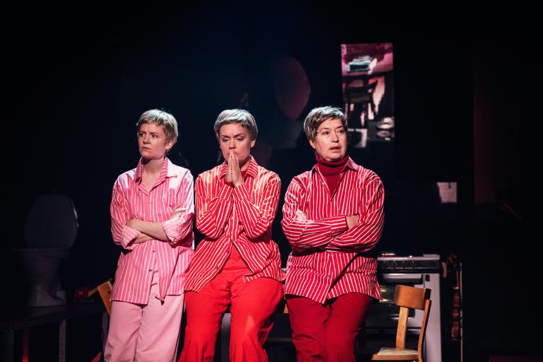 Tre personer i randiga skjortor står i rad, alla med armarna i olika positioner.