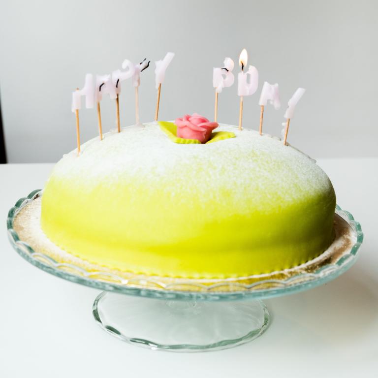 en prinsesstårta med utbrunna ljus som bildar Happy Bday