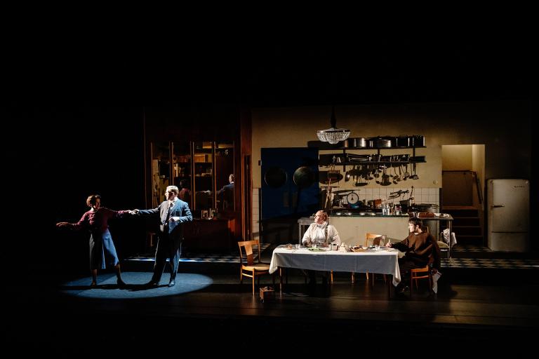 Två personer dansar till vänster i bild. Två personer till höger vid ett bord.