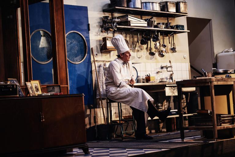 Person i kockkläder sitter ner