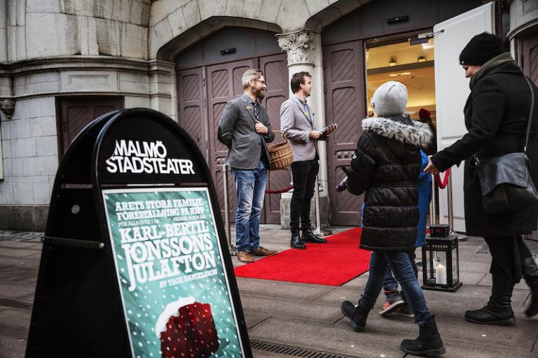 Två publikvärdar delar ut programblad och godis vid entrén till Hipp