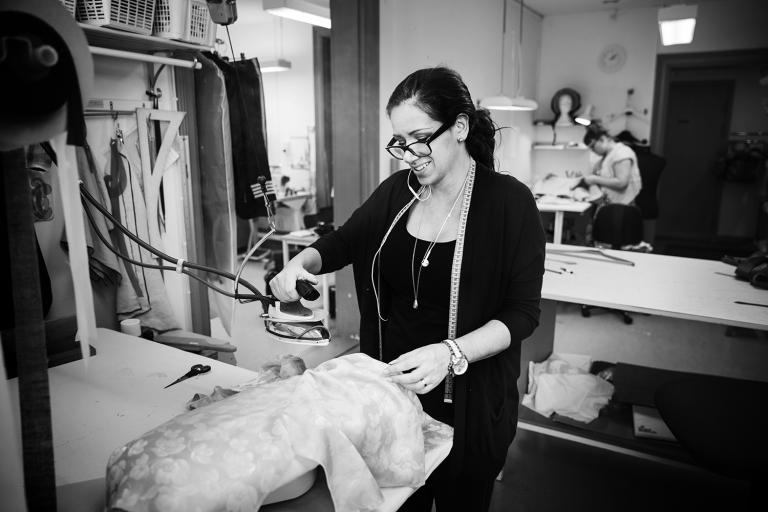 Skräddaren Andrea använder en maskin för att pressa kläder