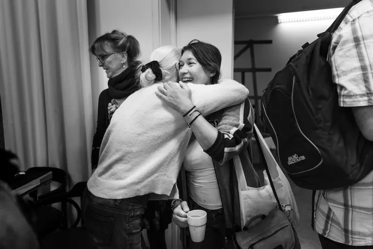 Skådespelarna Katarina Lundgren-Hugg får en kram av regissören Johanna Garpe vid entrén till replokalen.