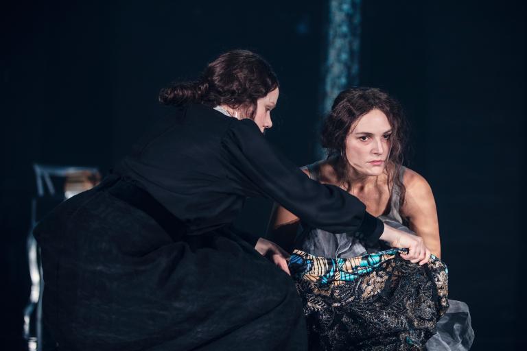 Foto Emmalisa Pauly Hedda sittandes. Tjänsteflickan till vänster.