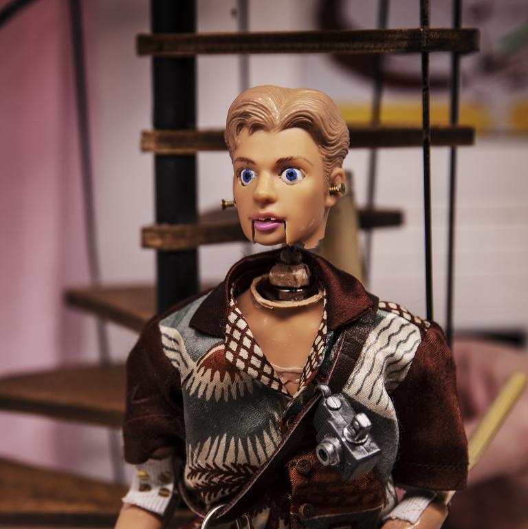 En manlig docka med en kamera runt halsen