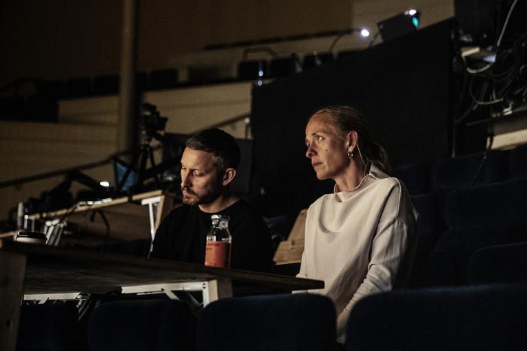 Regisören och Koreografen sitter vid ett temporärt arbetsbord bland sittplatserna i salongen.