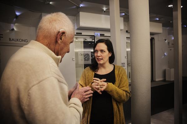 Syntolkare möter en besökare i foajén innan den syntolkade föreställningen Syntolkare möter en besökare i foajén