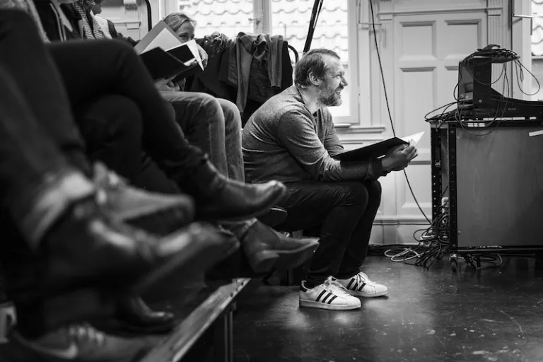 En medarbetare sitter med manuset bland publikplatserna på Studion.