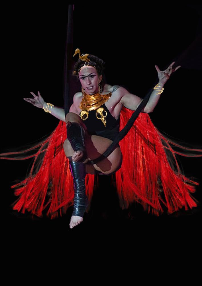 Kostymskiss föreställandes Gudinnan Inanna sittandes i ett trapetsliknande rep. Hon har en svart dräkt med guldsmycken och en röd mantel som liknar hår eller fjädrar. I pannan har hon ett guldsmycke i form av en fågel