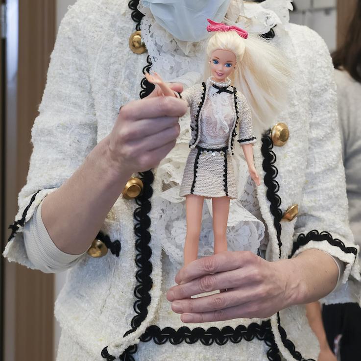 En kvinna och en Barbiedocka i likadana kostymer