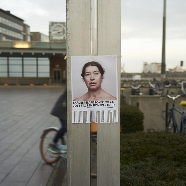 Affisch med skådespelare i utemiljö i Malmö. Text på affischen: "Skådespelare söker extrajobb till pensionssparande"