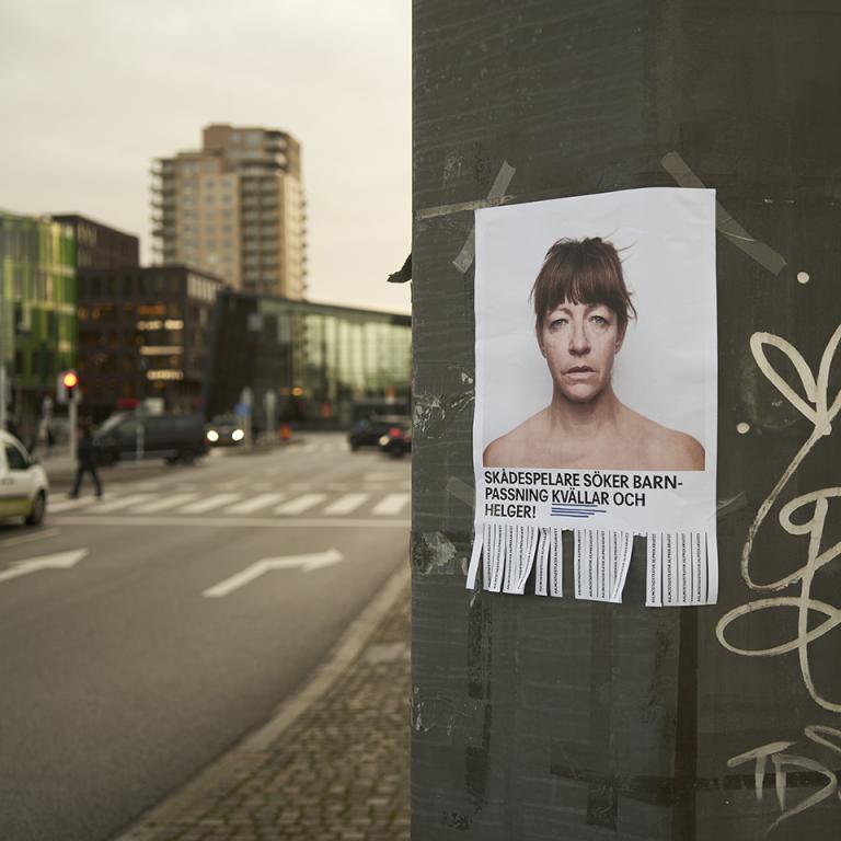 Affisch med skådespelare vid en av kanalbroarna i Malmö. Text på affischen "Skådespelare söker barnpassning kvällar och helger"