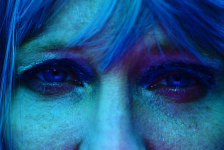 Närbild på en kvinnas ögon i blått ljus