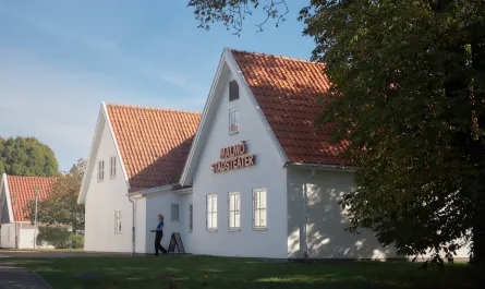 Exteriör bild Malmö Stadsteater Rosengård. Vitputsat hus med tegeltak, stor skylt Malmö Stadsteater