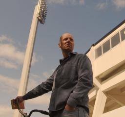 Man står med cykel framför Malmö fotbollsstadium 