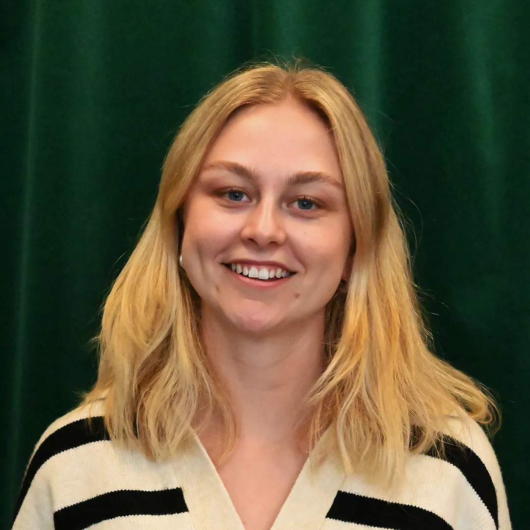 Linn Mattsson Tillberg. Tjej med blont hår, randig tröja framför en grön fond