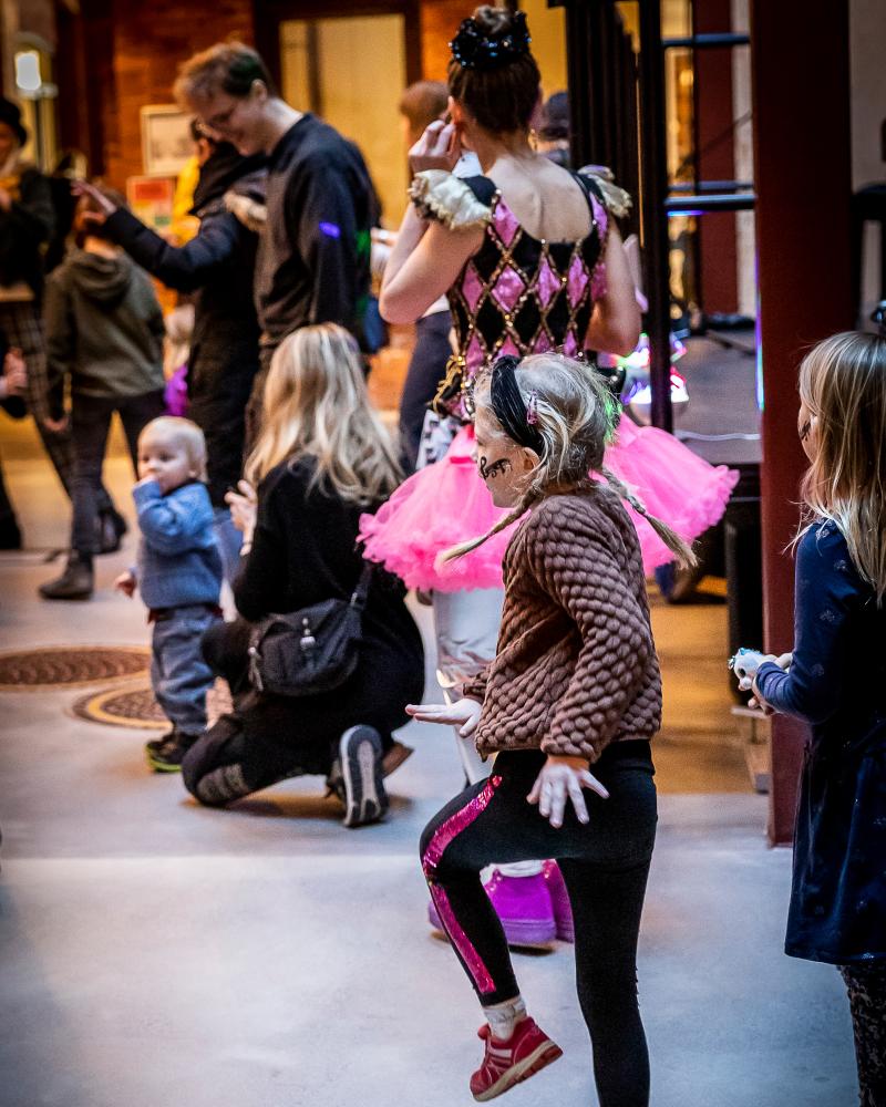 Jenny Baumgartner barn som dansar hoppsasteg, ballerina i bakgrunden tillsammans med andra familjer