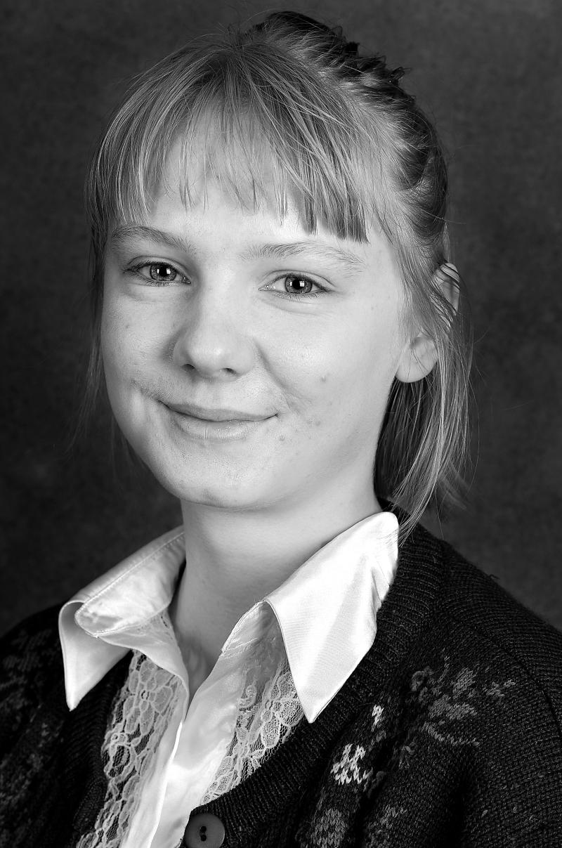 Porträttbild svartvit. Person med lugg, hår uppsatt och vit blus. 